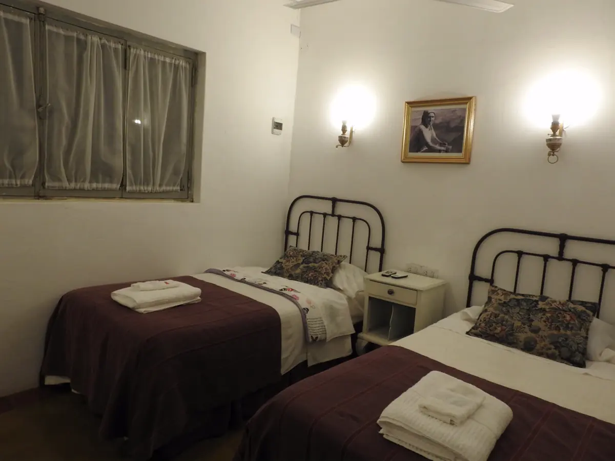 Habitación twin con dos camas de hierro y toallas